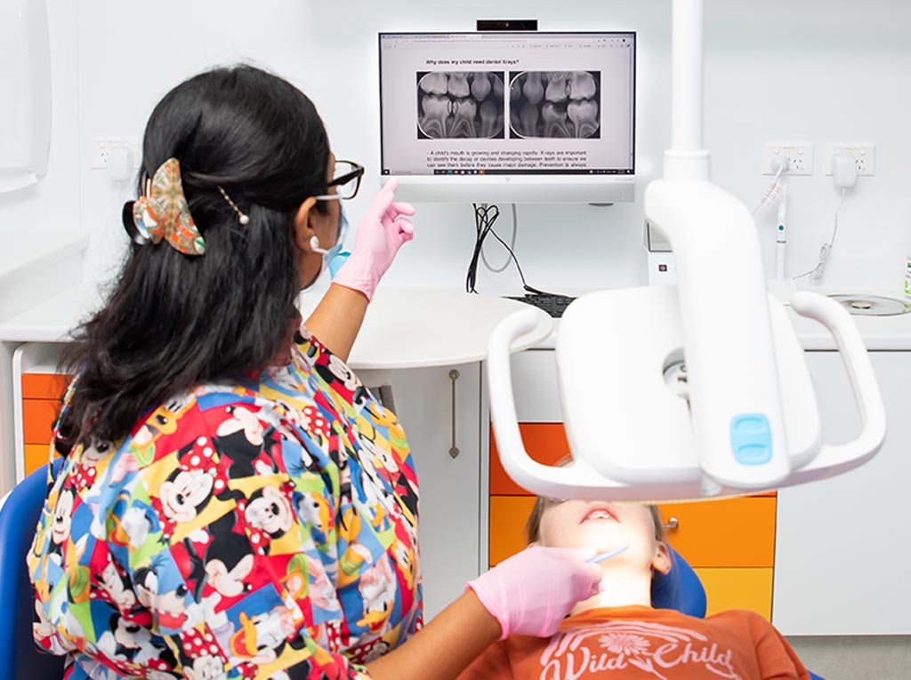 NLPD dentist reviewing a child's dental X-rays with the young patient during a consultation